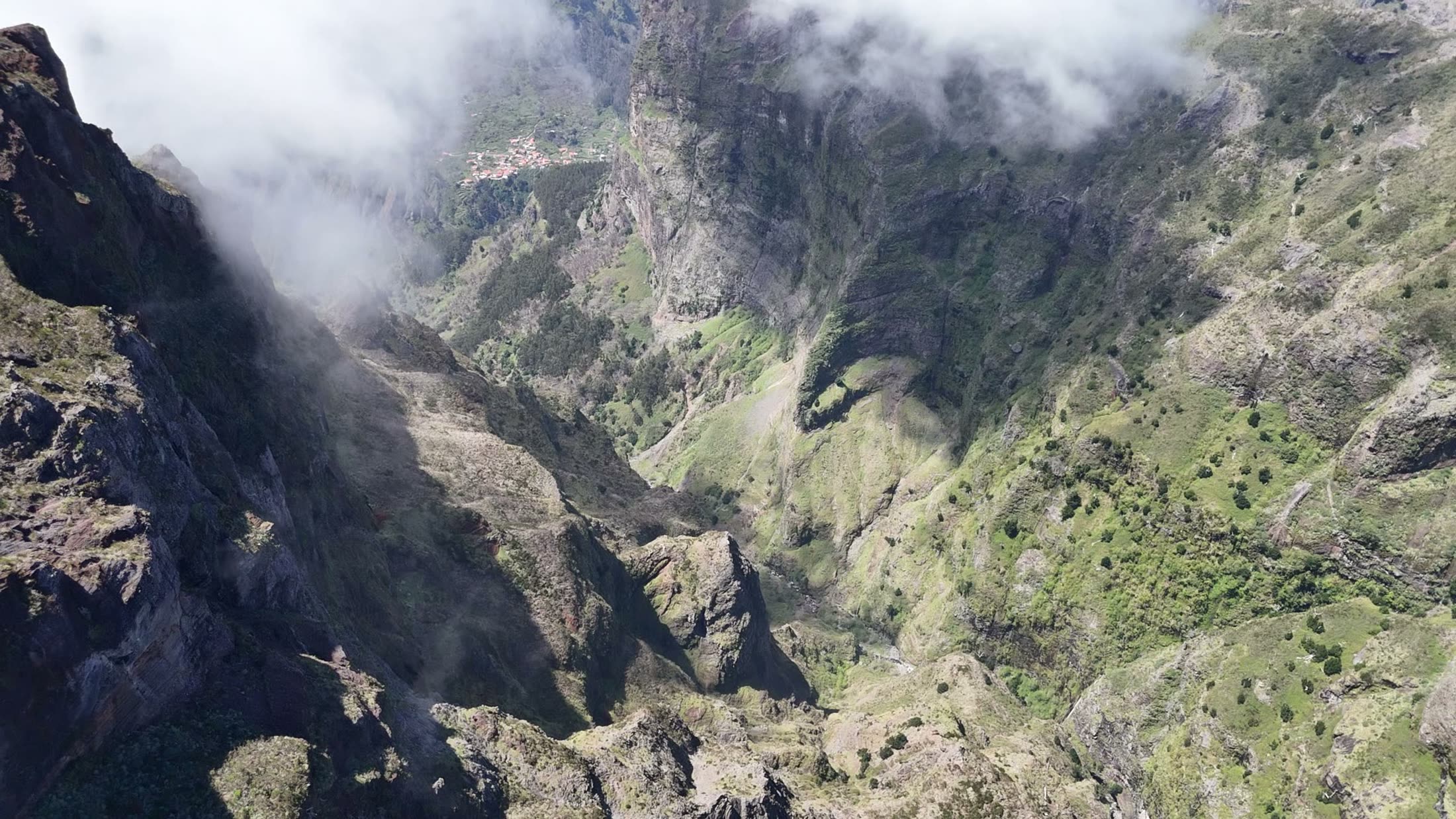 Aerial drone still over a misty green valley
